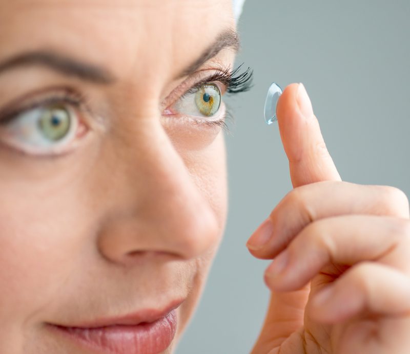 close up of a mature lady putting on contact lenses in her eyes